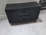 a black cabinet with two drawers in the middle of the room