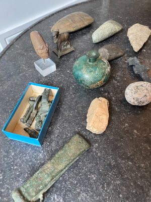 de nombreux objets posés sur la table et une boîte par terre