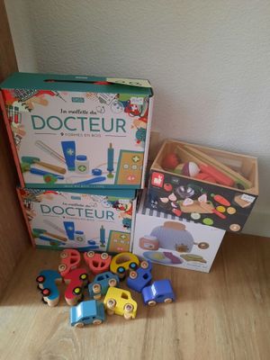 une boîte de jouets en bois posée par terre à côté d'une autre boîte de jouets en bois