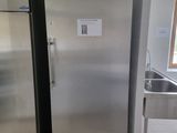a stainless steel refrigerator in a kitchen with a sink
