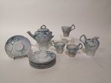 many plates and cups and a teapot on the table