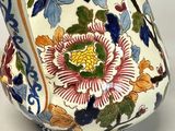 a vase with a floral design on it sitting on a table