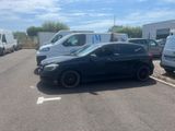 une voiture noire garée dans un parking à côté d'autres voitures