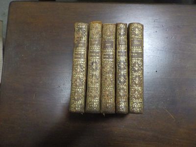 Trois vieux livres sont posés les uns à côté des autres sur une table en bois.