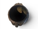 a close up of a small vase with a leaf in it