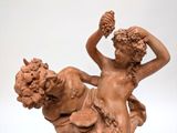 a statue of a woman holding a bunch of grapes