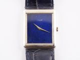 a close up of a watch with a blue face