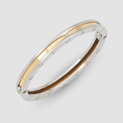 a close up of a silver and gold bang bracelet on a white background