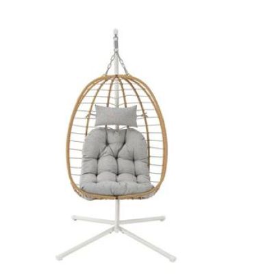 the hanging chair is made of wicker and has a cushion on it
