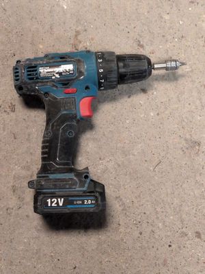 a drill that is laying on the ground next to a piece of wood