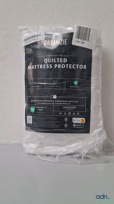 the mattress protector is in a plastic bag on a white surface