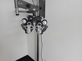 une photo d'une salle d'examen ophtalmologique équipée d'un écran et d'un projecteur