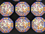 six blue and orange plates with birds and flowers on them