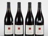 three bottles of red wine are lined up on a table