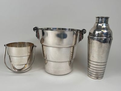 three silver vases and two cups on a white surface