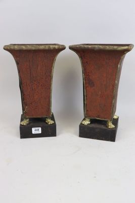 une paire de vases en bronze reposant sur des socles noirs, sur fond blanc