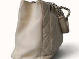 beige leather handbag with chain strap on a white background