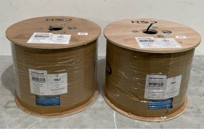 two reels of cable wrapped in plastic on the floor