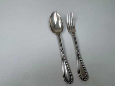 two spoons and a fork on a white table