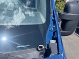 a blue truck that has a mirror on the side of it