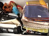 a pile of folded towels and other items on a shelf