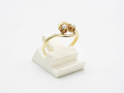 Gros plan sur une bague en or ornée d'une perle