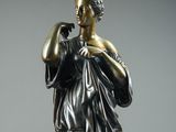 bronze statue of a woman with a flute in her hand
