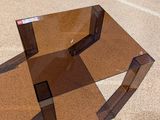 a glass table with a mirror on it on the ground