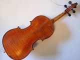 an old violin sitting on top of a table next to a white wall