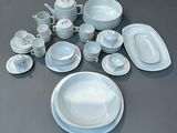 a lot of white plates and bowls on the table