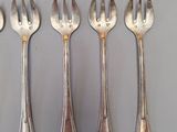 six forks and spoons are arranged in a row on a table