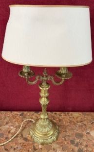 a lamp that is sitting on a table with a red wall in the background