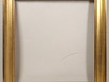 a gold picture frame on a white wall with a white background