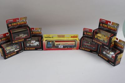six petites voitures et un camion, tous emballés, dans une vitrine