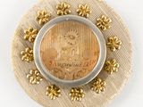 a coin in the center of a button with flowers around it