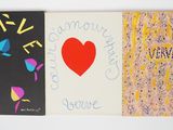 Trois livres sont alignés sur une surface blanche, avec un cœur rouge au milieu.
