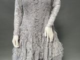 a mannequin wearing a gray dress with feathers on it