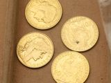 quatre pièces d'or posées dans une boîte en carton sur une table