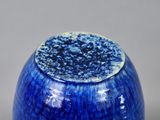 a close up of a blue vase on a table
