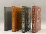 quatre livres sont alignés sur une surface blanche
