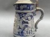 a blue and white vase with a cup on it
