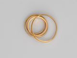 a close up of three gold rings on a white surface
