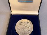 an image of a silver medal in a blue case