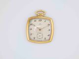 a small gold pocket watch sitting on a white surface