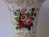 un vase blanc avec des fleurs posé sur une table