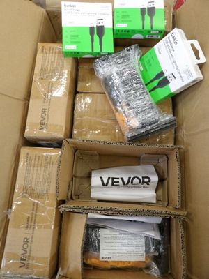 de nombreuses boîtes contenant des appareils électroniques, empilées dans une boîte posée par terre