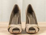 pair of women ' s shoes on a wooden table with a curtain in the background
