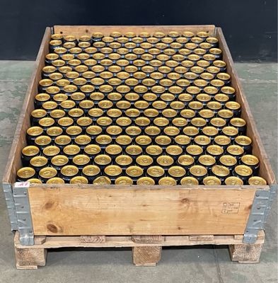 une caisse en bois remplie de canettes de bière posée sur un sol en béton