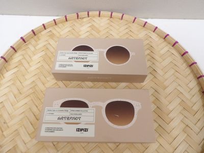 deux boîtes de lunettes de soleil posées sur un panier