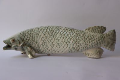 une statue de poisson posée sur une surface blanche